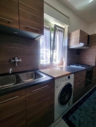 a kitchen with a sink and a washing machine at Case Gemelle - CIR 0271 in Aosta