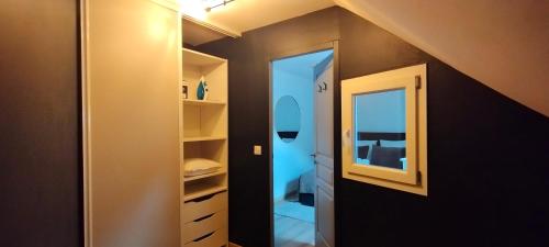 une chambre mansardée avec un miroir et un placard dans l'établissement La Suite Des Légendes - Duplex climatisé - Centre historique, à Dole