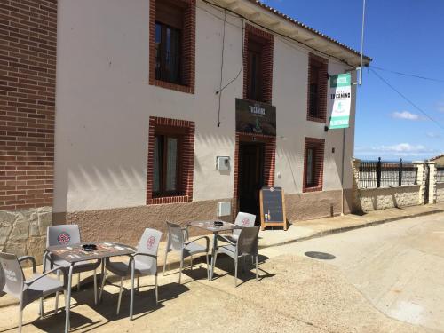 two tables and chairs in front of a building at Albergue Vive tu Camino in Reliegos