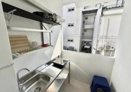 Una pequeña cocina con fregadero y ventana. en Patong Canal Villa R208, en Patong Beach