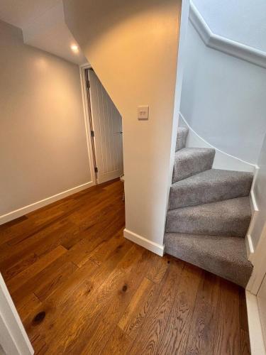 Un pasillo vacío con escaleras en una casa. en Fresh comfy space, feel at home., en Kent