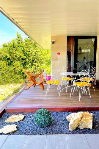 a deck with a table and chairs on it at Appartement, Nature, Relaxation et Demi-Pension Possible in Crévic