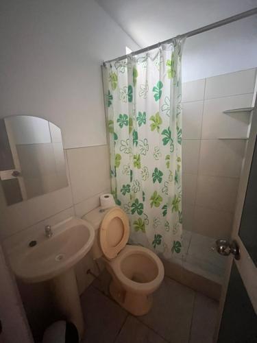 a bathroom with a toilet and a sink and a shower curtain at Zzi in Lamas