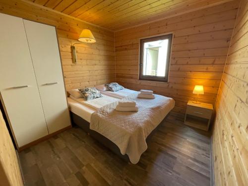 a bedroom with a bed in a wooden cabin at Domki Przewłoka in Przewłoka