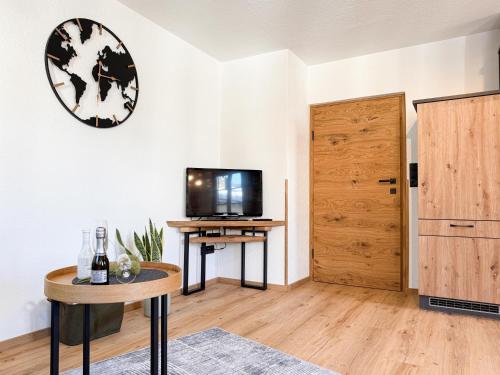 a living room with a tv and a table and a door at Haus Carolus in Elbigenalp