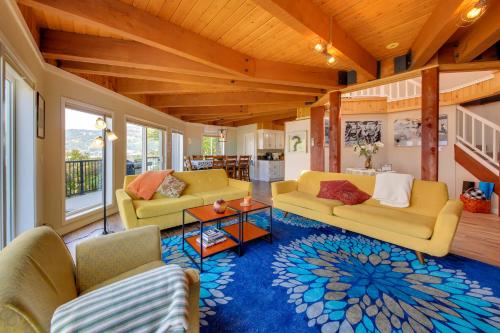 a living room with yellow couches and a blue rug at Stellar Views! Lake Pend Oreille Retreat with Dock in Sagle