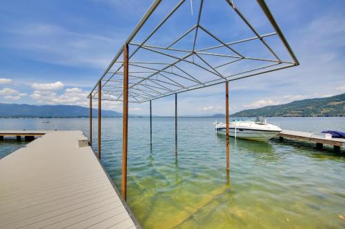 a boat sitting on the water next to a dock at Stellar Views! Lake Pend Oreille Retreat with Dock in Sagle