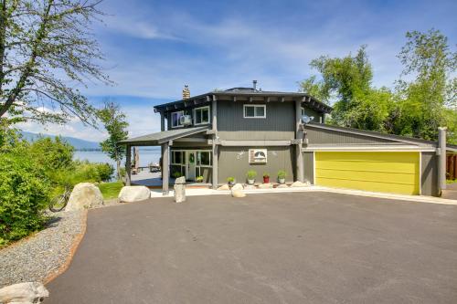 a house with a yellow garage in the driveway at Stellar Views! Lake Pend Oreille Retreat with Dock in Sagle
