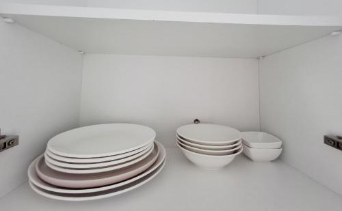 two stacks of plates and a toilet in a room at Bright Spacious Family Apartment in White Sails in Batumi