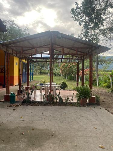 a pavilion with a table and chairs in a park at Hacienda Villa Liria in Hobo