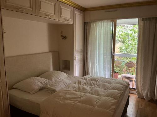 une chambre avec un lit et une grande fenêtre dans l'établissement Appartement Monseigneur, à Vannes
