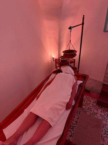 a person laying on a bed in a room at Al Fundok Boutique Hotel in Maasser El Chouf