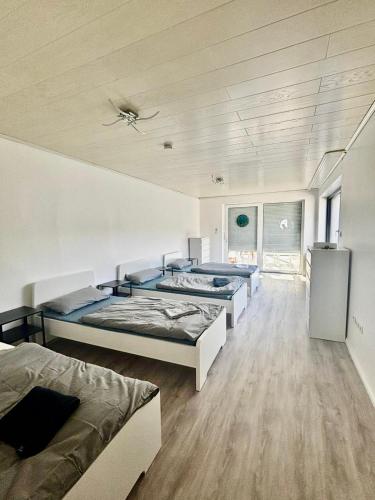 a bedroom with three beds and a ceiling at Pension Hüttengrund in Achim