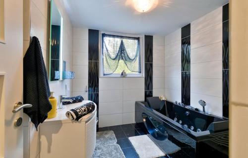 a bathroom with a sink and a tub and a window at Ferienhaus Reny in Zadoborje