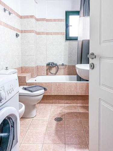 a bathroom with a tub and a toilet and a sink at Menidi by the sea in Menídion