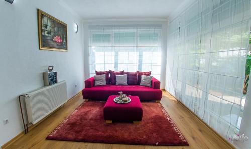 a living room with a red couch and a table at Villa Dar Počitelj in Čapljina