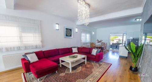 a living room with a red couch and a table at Villa Dar Počitelj in Čapljina