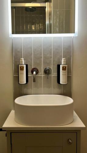 a bathroom sink with two bottles of soap on it at Cosy Cottage Kendal in Kendal