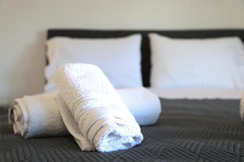 two rolled up towels sitting on a bed at White Ruby Sea Side Studio in Kavala