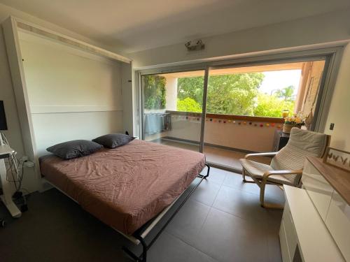 une chambre avec un lit et une grande fenêtre dans l'établissement Oasis Littorale, à La Ciotat