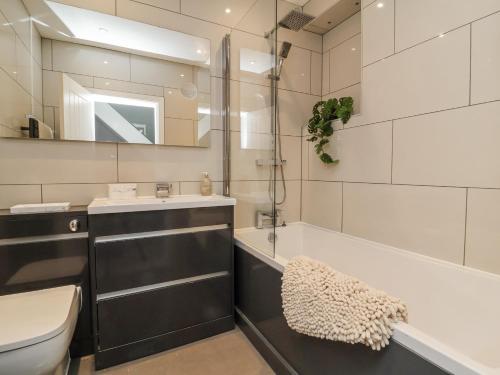 a bathroom with a sink and a tub and a toilet at Beach Hideaway in Bideford