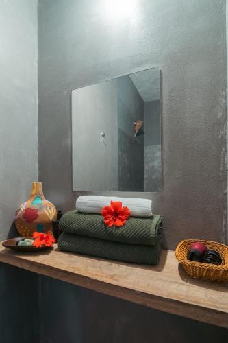 a pile of towels sitting on a shelf in front of a mirror at Pousada Kiarô Caraíva in Caraíva