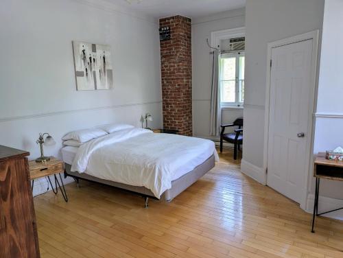 a bedroom with a bed and a desk and a window at Aux petits oiseaux in Baie-Saint-Paul