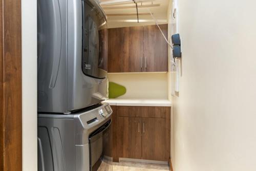 a small kitchen with a refrigerator and wooden cabinets at Basingdale Hollow - For 10 in Vail