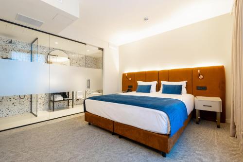 een slaapkamer met een groot bed en een groot raam bij The Liman Hotel in Brussel