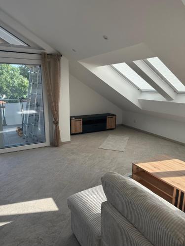 a living room with a couch and a large window at Ferien Penthaus Wohnung Brunnthal in Brunnthal
