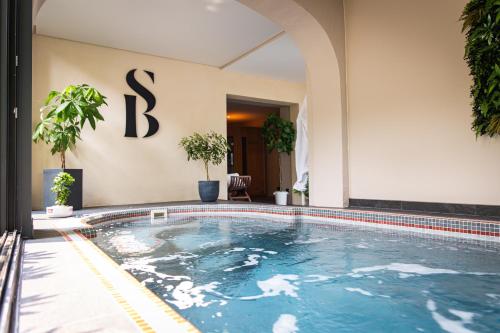 a swimming pool in front of a hotel at Hotel de Charme Le Sud Bretagne in Pornichet