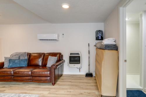 a living room with a leather couch and a air conditioner at Walk to Norfork Lake Guest House in Henderson in Henderson