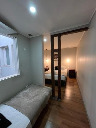 a bedroom with two beds and a window at BbCasita Blue in Santiago