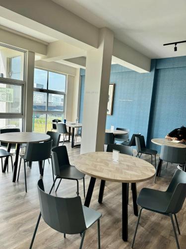 a dining room with tables and chairs and windows at New Bamboo Horizon pool, gym and coworking in Querétaro