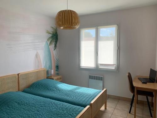a bedroom with a bed and a desk and a window at La Jalé in Saint-Georges-dʼOléron