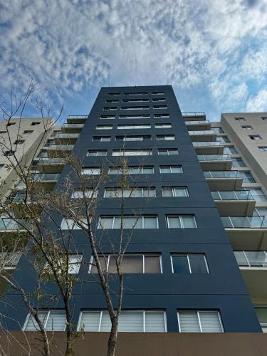 a tall blue building with trees in front of it at New Bamboo Horizon pool, gym and coworking in Querétaro