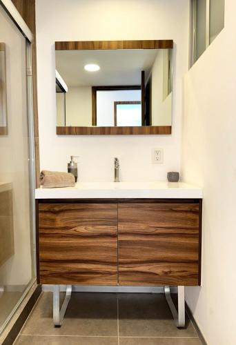 a bathroom with a sink and a mirror at New Bamboo Horizon pool, gym and coworking in Querétaro