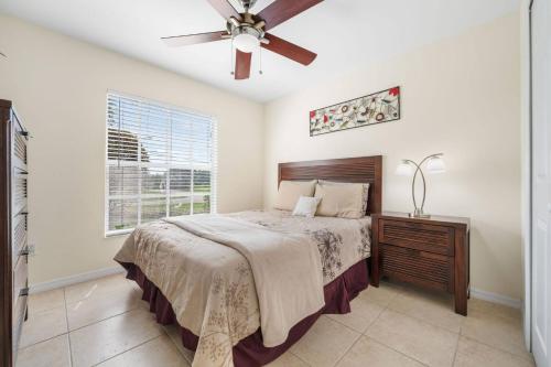 珊瑚角Villa Yvonne的一间卧室，里面有一张床和一个吊扇