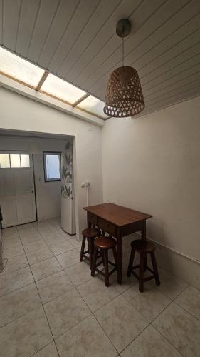 a dining room with a wooden table and stools at Casa dos trevos in Pataias