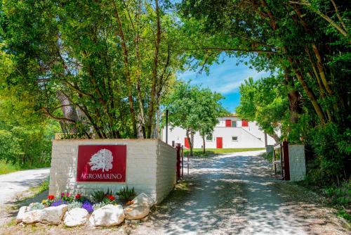 a sign in front of a building with trees at Agromarino in Sirolo