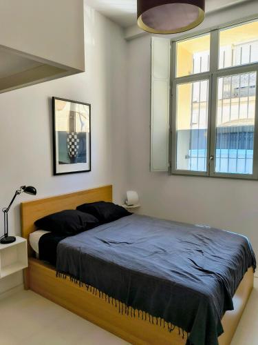 une chambre avec un lit et une grande fenêtre dans l'établissement Be For You, à Montpellier