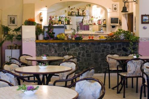 a restaurant with tables and chairs and a bar at Hotel Gemma in Ischia