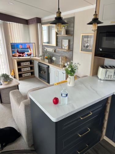 a kitchen and living room with a white counter top at Mimosa lodge in Little Clacton