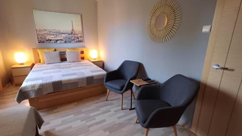 sypialnia z łóżkiem, 2 krzesłami i stołem w obiekcie Rajska Apartament- Gdańsk w Gdańsku
