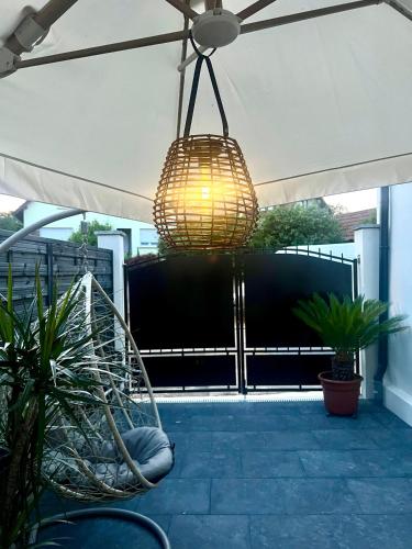 une lumière suspendue à un auvent sur une terrasse avec des plantes dans l'établissement La Villa Dorée & SPA Netflix Parking Wifi, à Kurtzenhouse