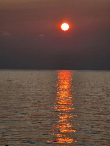a sunset over the water with the sun setting at Sunny Beach Hotel in K'obulet'i