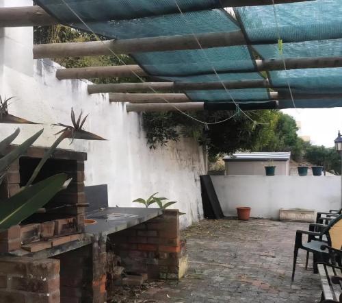 a patio with a stone fireplace and a blue roof at Casa dos trevos in Pataias