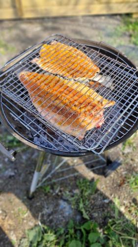 a grill with several types of food on it at Villa med pool i närheten av Örebro in Hällefors