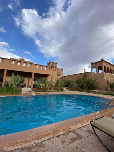 a large swimming pool in front of a building at Auberge Famille Benmoro in Skoura