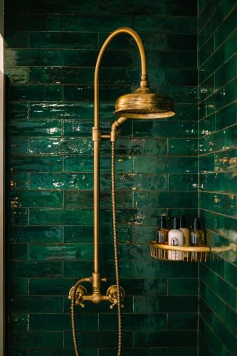 a shower in a bathroom with green tiles at Hotel Son Molí Country House in Playa de Palma